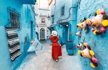 young-woman-with-red-dress-visiting-the-blue-city-chefchaouen-marocco